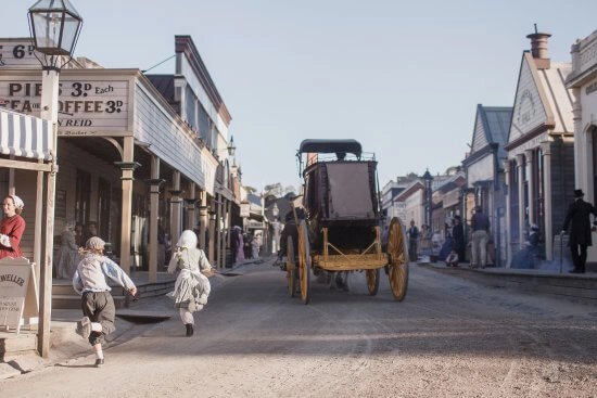 Horse-drawn carriage travelling down the dirt main street of the Sovereign Hill outdoor museum precinct in Ballarat.