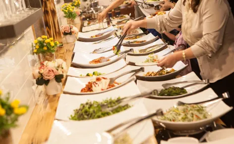 Event guests serving themselves from an artisan buffet and grazing spread catered by Peter Rowland.