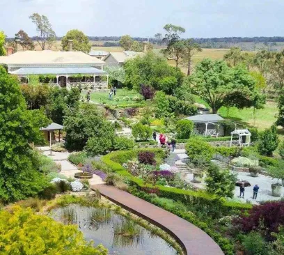 Elevated view of Narmbool heritage gardens featuring winding boardwalks, ponds, and historic homestead grounds in regional Victoria.