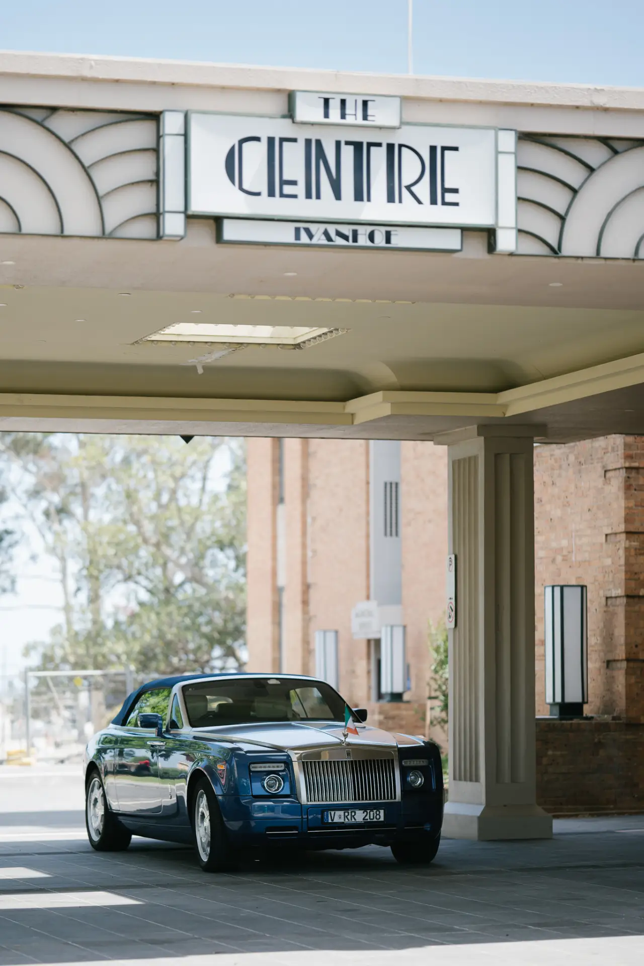 Classic green convertible parked under the Art Deco porte-cochère entrance of The Centre Ivanhoe.