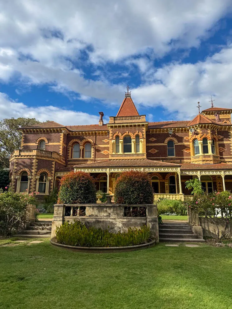 Exterior view of the historic Rippon Lea Estate Victorian mansion and manicured lawn gardens in Melbourne.