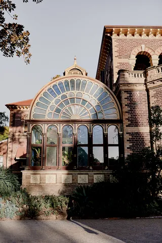 Architectural detail of the historic glass conservatory attached to the polychrome brick mansion at Rippon Lea Estate.