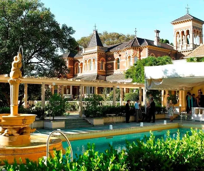 Rippon Lea Estate historic brick mansion overlooking the ornamental swimming pool and garden fountain.
