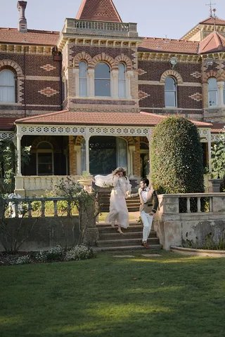 Formal guests on the stone verandah steps of the historic Rippon Lea Estate mansion.